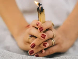 manos-de-mujer-cogiendo-un-palo-santo-encendido-como-ritual