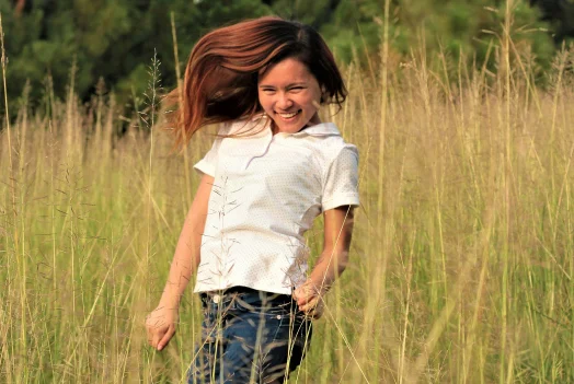 persona-sonriendo-y-caminando-entre-hierba-alta.