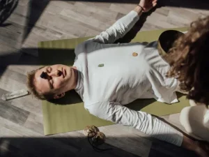hombre-recostado-en-el-suelo-recibiendo-armonización-de-chakras