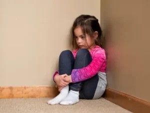 niña-castigada-sola-sentada-en-una-esquina-de-la-habitacion