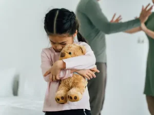 niña-abrazando-su-peluche-papa-discutiendo