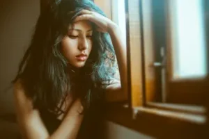 mujer-triste-al-lado-de-la-ventana
